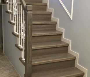 Фото лестницы на бетонных ступенях в Плещеницах: отделка массивом дуба, тёмная тонировка, дубовые поручни.