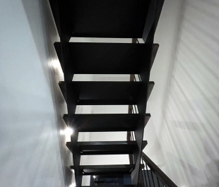 Фото лестницы с дубовыми ступенями тёмного ореха и металлическими балясинами