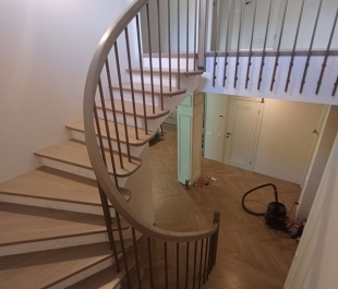 Фото лестницы с дубовыми ступенями и металлическими ограждениями с деревянным поручнем